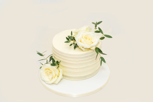 Two-Tier White Wedding Cake With Flowers and Greenery