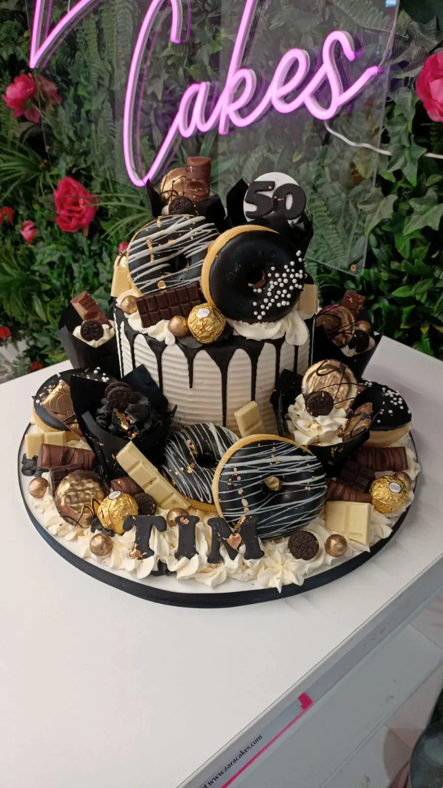 Gold & Black Overload cake with cupcakes & doughnuts – Zara Cakes